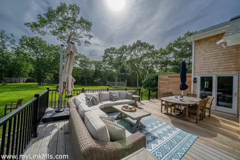 a view of a patio with couches potted plants and a big yard