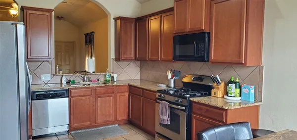 a kitchen with stainless steel appliances granite countertop a stove a sink and a microwave