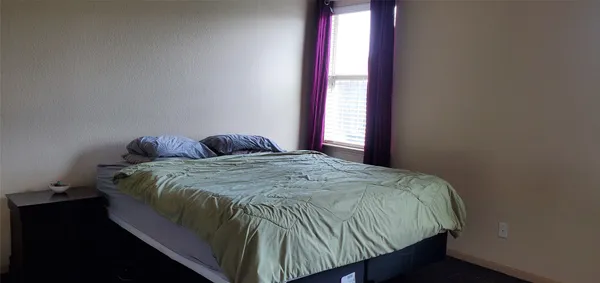 a bedroom with a bed and window