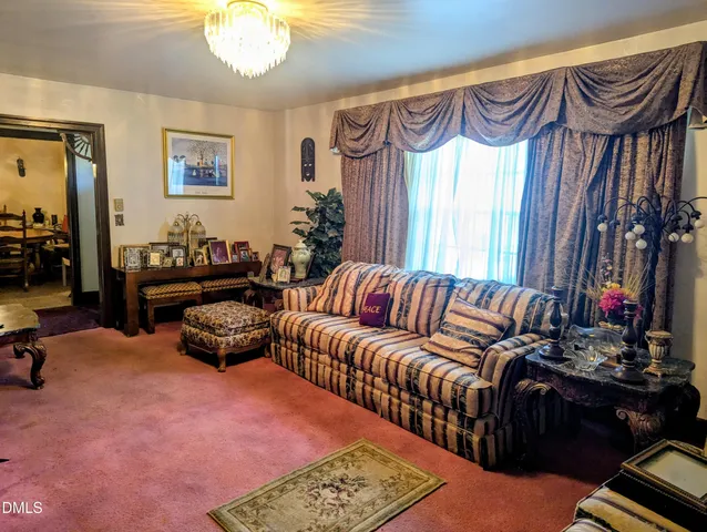 a living room with furniture a lamp and a chandelier
