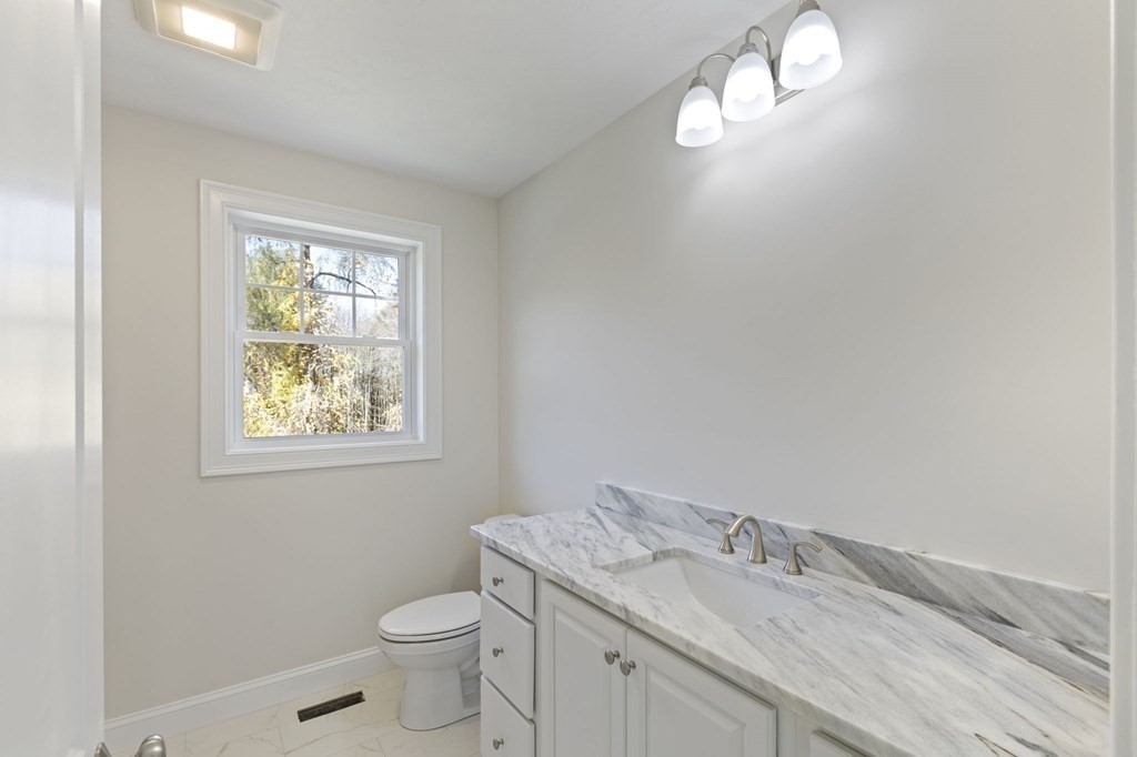 171 Rangeway Road North Billerica, MA 01862 - Photo 16 of 35 a bathroom with a granite countertop toilet a sink and a window