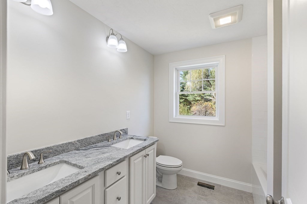 171 Rangeway Road North Billerica, MA 01862 - Photo 21 of 35 a bathroom with a granite countertop sink a toilet and a window