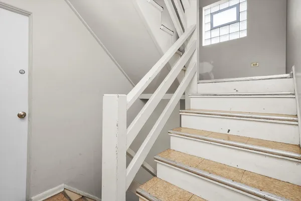 a view of staircase with white walls and a window