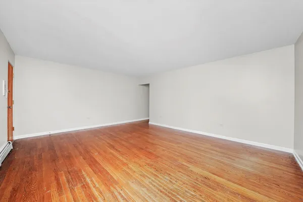 a view of an empty room and wooden floor