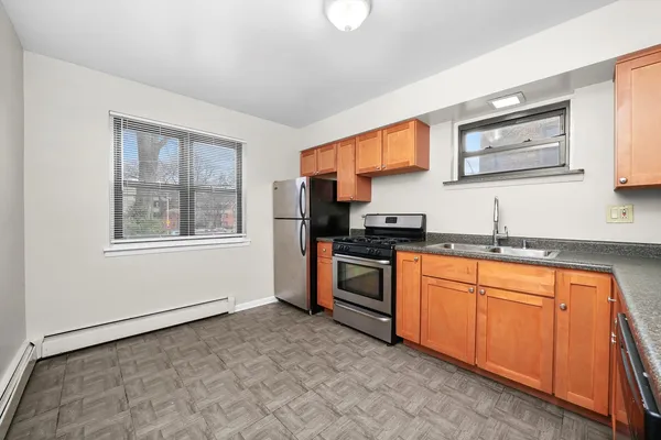 a kitchen with stainless steel appliances granite countertop a stove a sink and a refrigerator