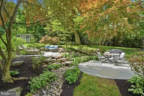 a view of a backyard with plants and outdoor seating