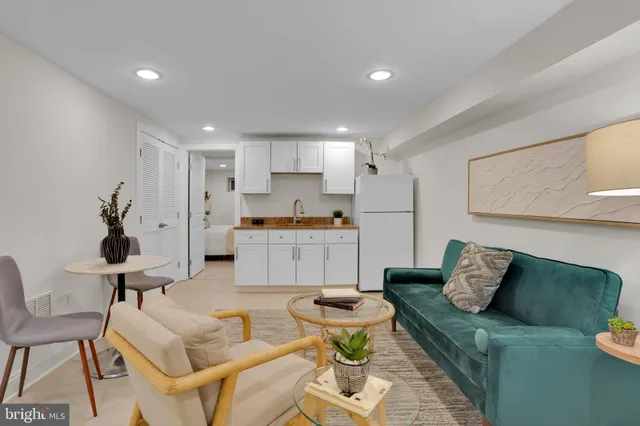 a living room with furniture and kitchen view