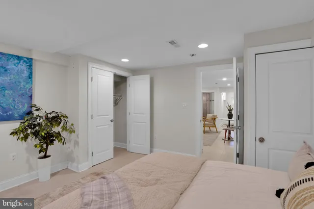 a bedroom with a bed and a potted plant
