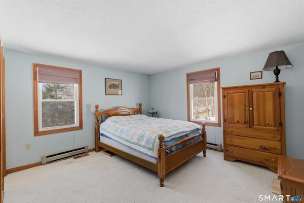 a bed sitting in a bedroom next to a window