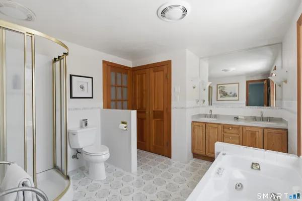 a spacious bathroom with a granite countertop sink toilet and shower
