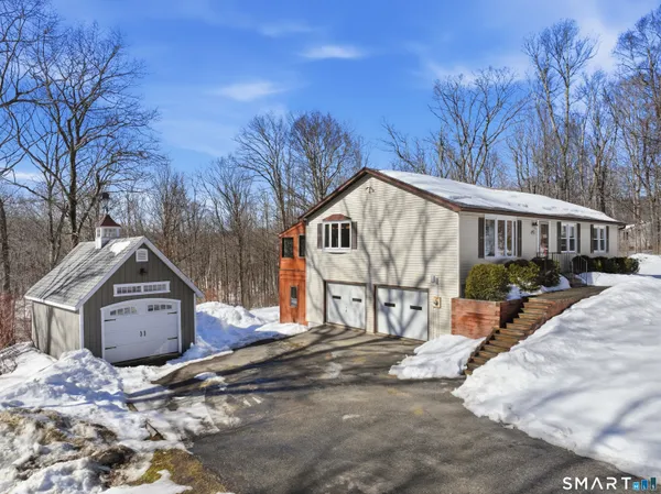 a view of a house with snow on the side of the road