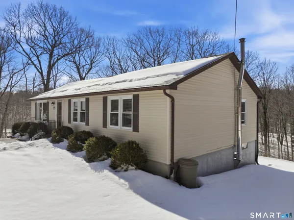 a view of a house with a yard covered in snow