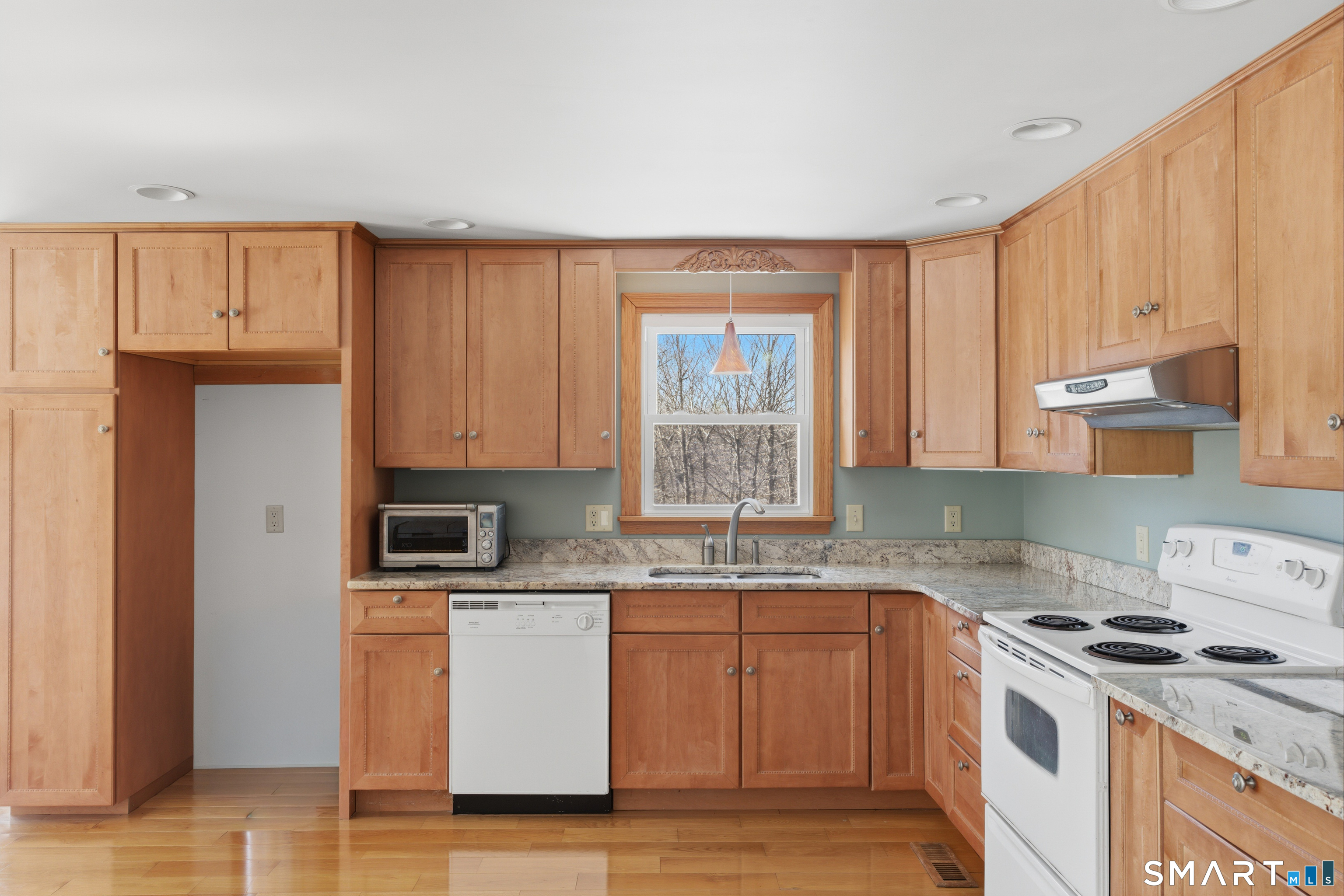 1616 Weed Road Torrington, CT 06790 - Photo 10 of 40 a kitchen with stainless steel appliances granite countertop a stove a sink and white cabinets with wooden floor