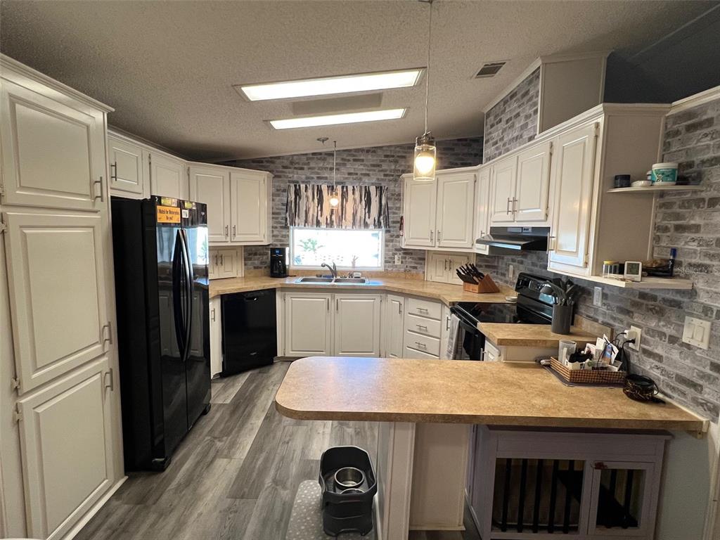 1001 Starkey Road, Unit 731 Largo, FL 33771 - Photo 5 of 35 a kitchen with kitchen island a sink stove and refrigerator