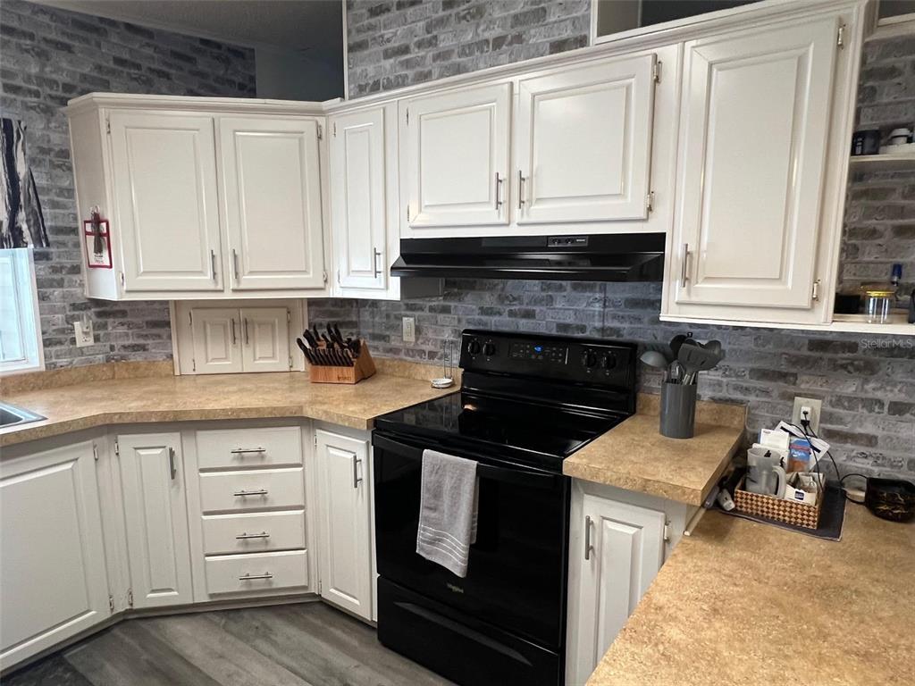 1001 Starkey Road, Unit 731 Largo, FL 33771 - Photo 8 of 35 a kitchen with granite countertop a stove sink and cabinets