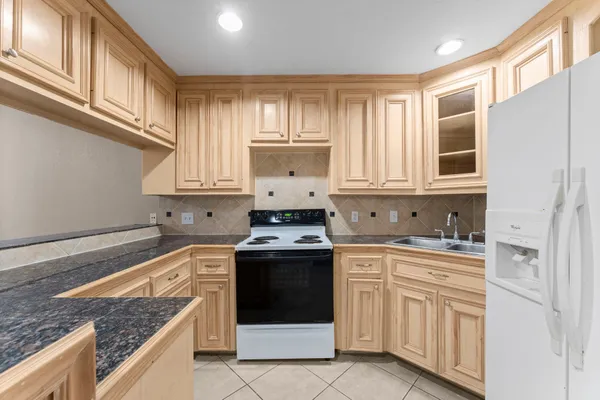 a kitchen with granite countertop white cabinets and white appliances