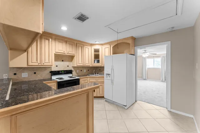 a kitchen with white cabinets and refrigerator