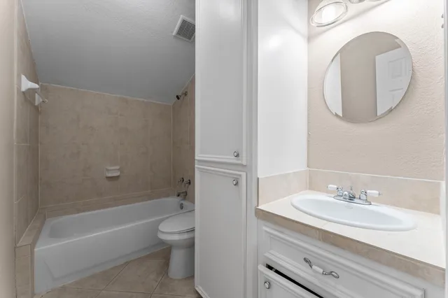 a bathroom with a granite countertop sink a toilet and a mirror