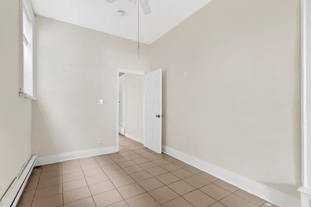 an empty room with chandelier fan