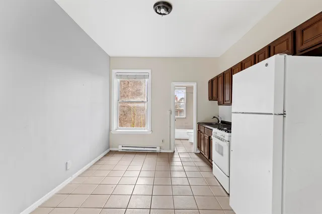 a view of a kitchen with a refrigerator cabinet a sink and dishwasher kitchen view