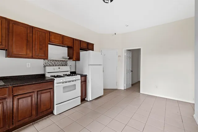 a kitchen with a stove a refrigerator and cabinets
