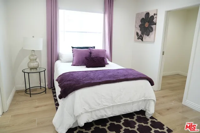a bedroom with a bed and wooden floor