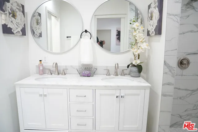 a bathroom with a granite countertop sink a mirror and shower curtain