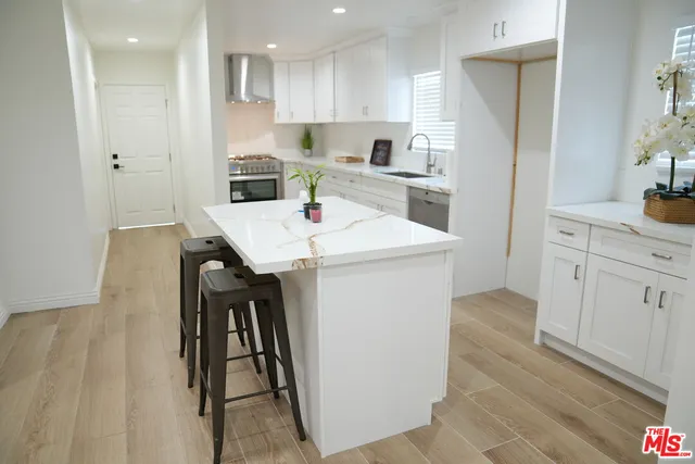 a kitchen with a sink a refrigerator and white cabinets
