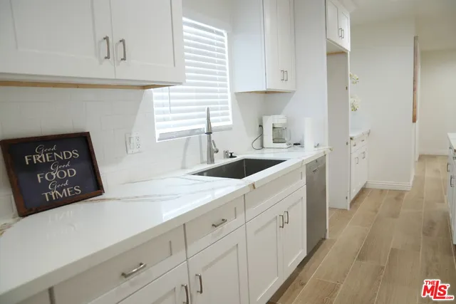 a kitchen with granite countertop white cabinets and white appliances