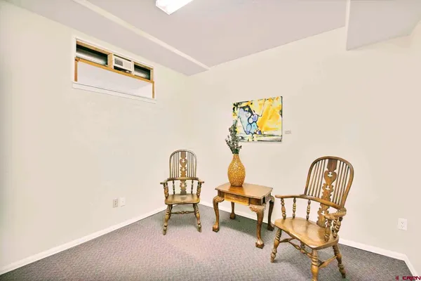 a view of a workspace with furniture and a window