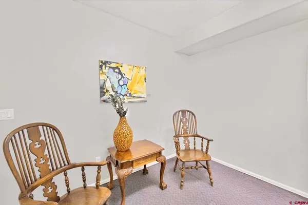 a view of a hallway with wooden floor and a dining room