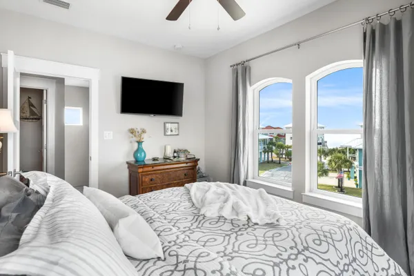 a bedroom with a bed a flat screen tv and a window