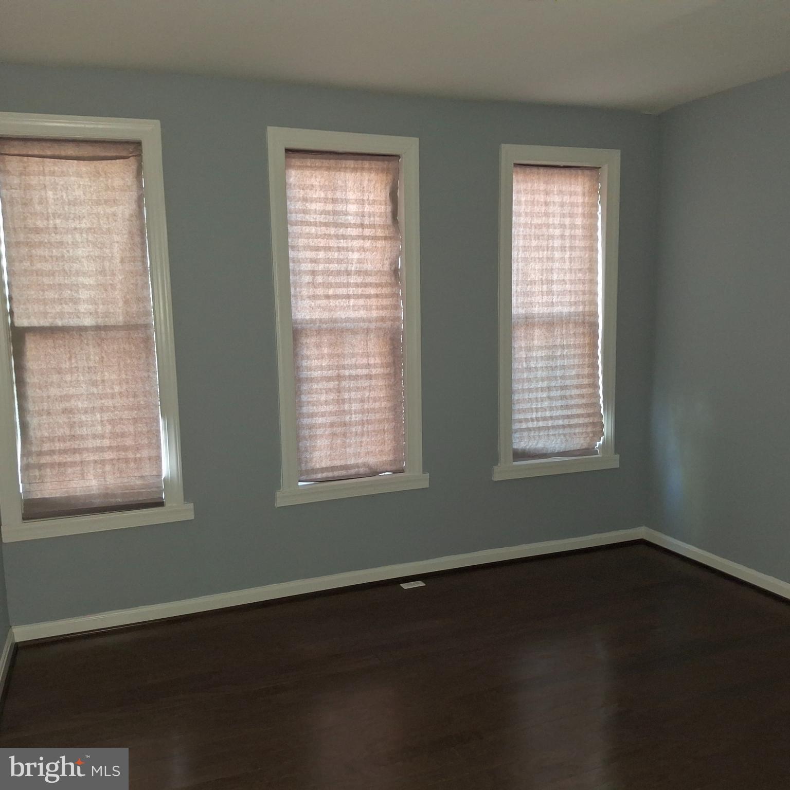 1403 Ramsay Street Baltimore, MD 21223 - Photo 16 of 30 a view of an empty room with wooden floor and a window