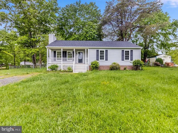 a front view of a house with a garden and trees