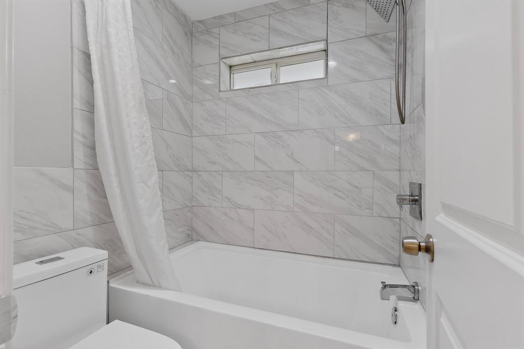 7631 Meadow Road Dallas, TX 75230 - Photo 25 of 40 Bright bathroom with a tub and toilet