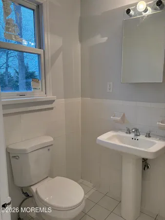 a bathroom with a sink a toilet and a mirror