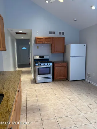 a kitchen with stainless steel appliances granite countertop a stove a sink and a refrigerator