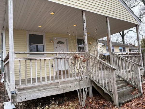 a view of wooden deck and a yard with wooden fence and a porch