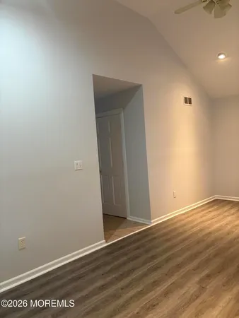 a view of an empty room with wooden floor