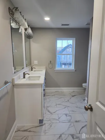 a bathroom with a sink a vanity a mirror and a shower