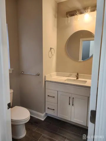 a bathroom with a toilet a sink a vanity and mirror