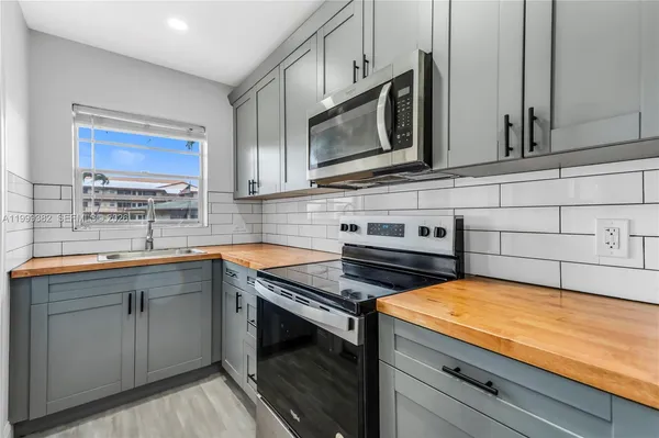 a kitchen with stainless steel appliances a stove microwave and cabinets
