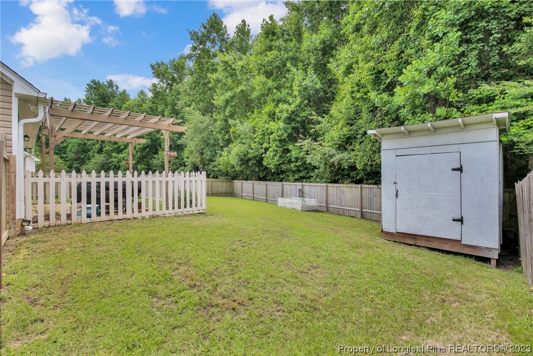 234 Cape Fear Road Raeford, NC 28376 - Photo 28 of 33 a view of a backyard with a fence and trees