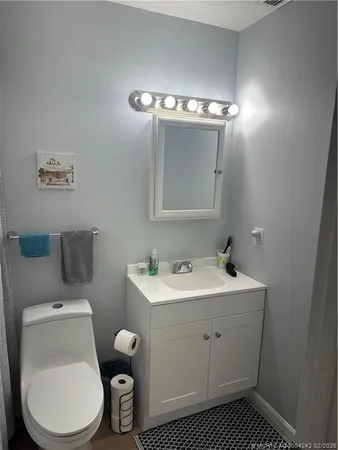 a bathroom with a toilet a sink and mirror