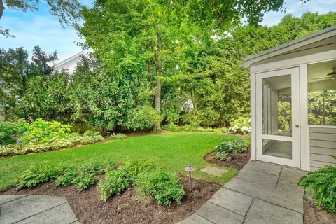 a view of backyard with potted plants and a bench