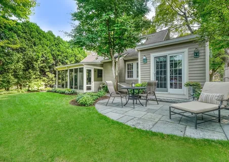 a view of a house with a backyard and chairs