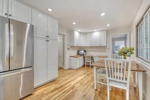 a kitchen with stainless steel appliances refrigerator dining table and chairs