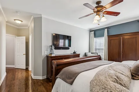 a bedroom with a bed and a flat tv screen on dresser