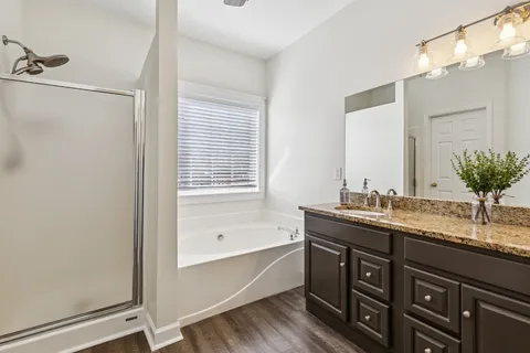a bathroom with a granite countertop sink mirror and a bathtub