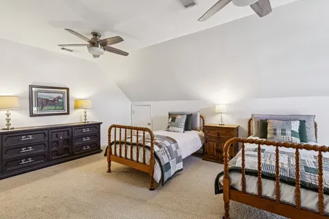 a bedroom with two beds and painting on the wall